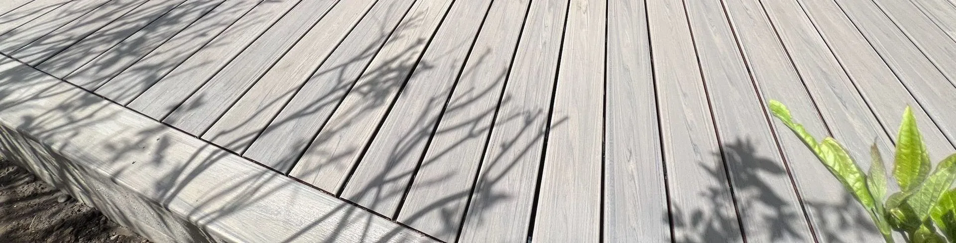 Modern grey wood deck with tree shadows