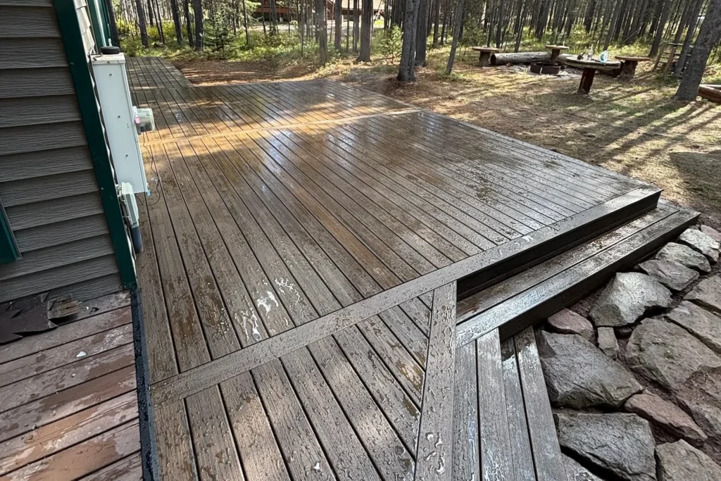 Wet wooden deck with steps and stone landscaping