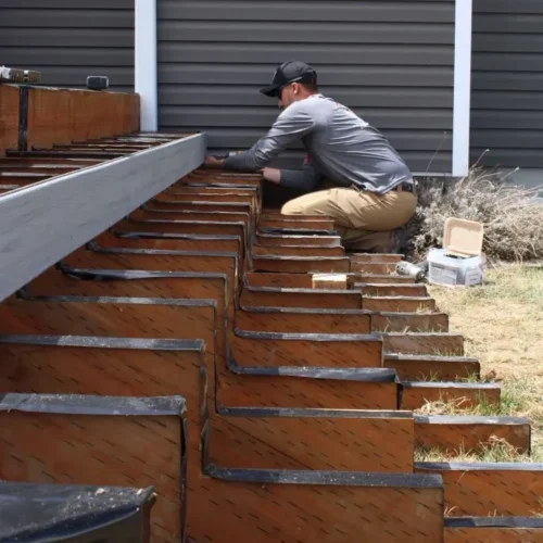 Construction worker installing deck stairs