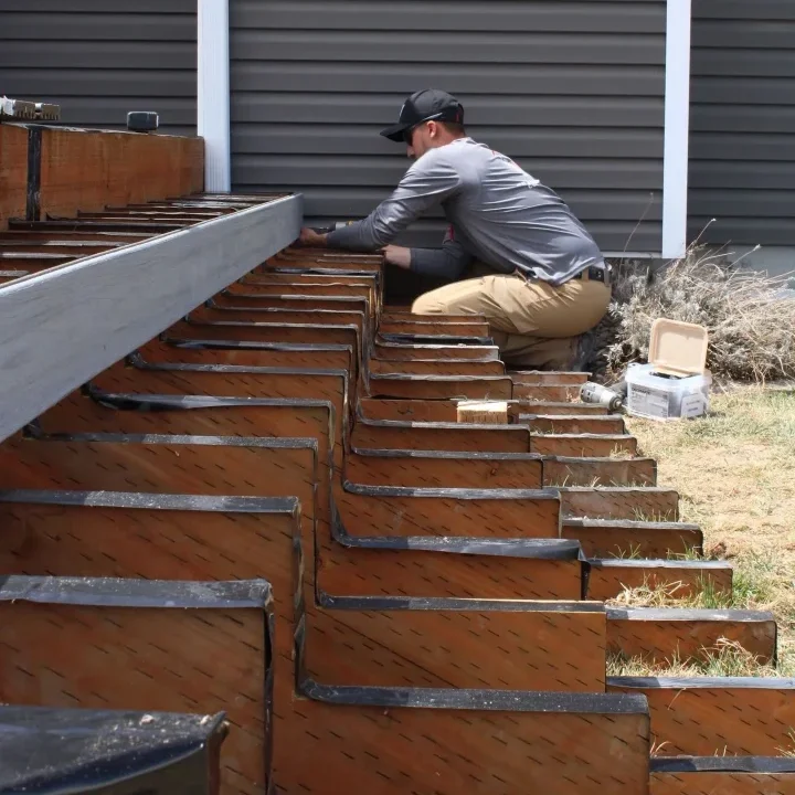 Construction worker installing deck stairs
